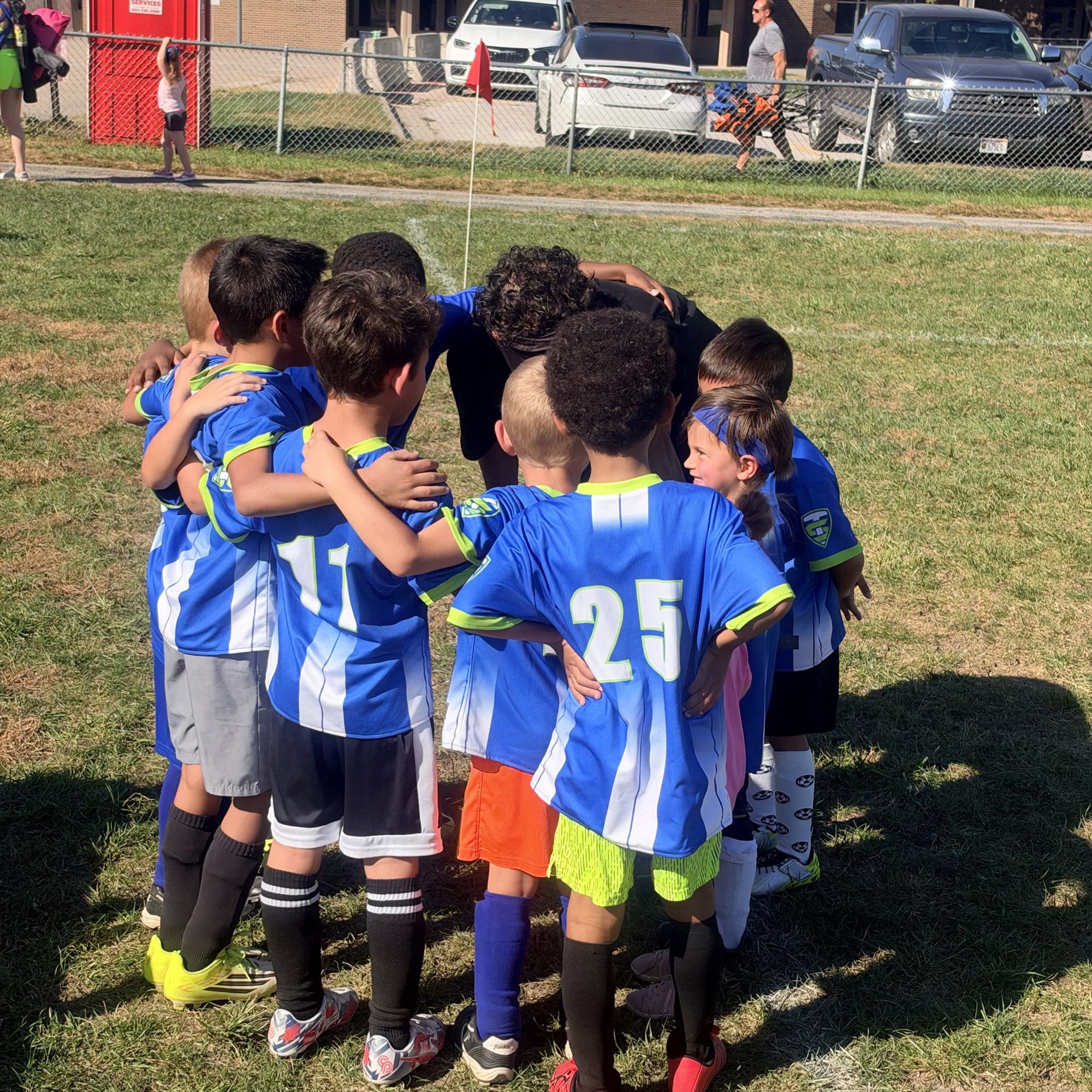 A youth soccer team huddled together